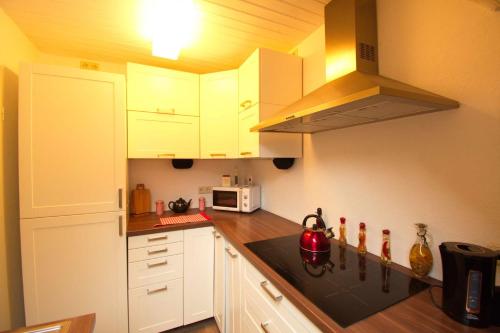 a kitchen with white cabinets and a stove top oven at Haus Maria in Ratzeburg