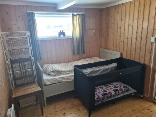 a small bedroom with a bunk bed and a window at Lite hus ved sjøen 