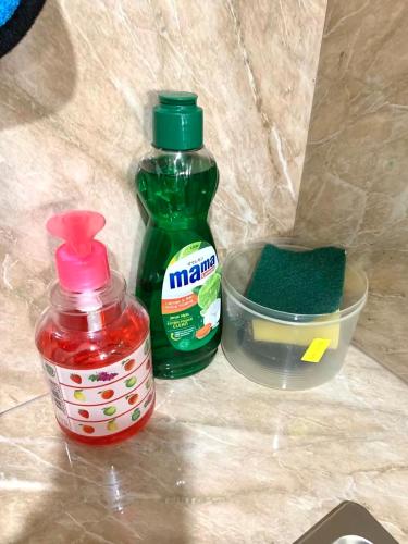 a bottle of ketchup and a container of green sauce at Wiwi Formosa Residence Nagoya Batam in Nagoya