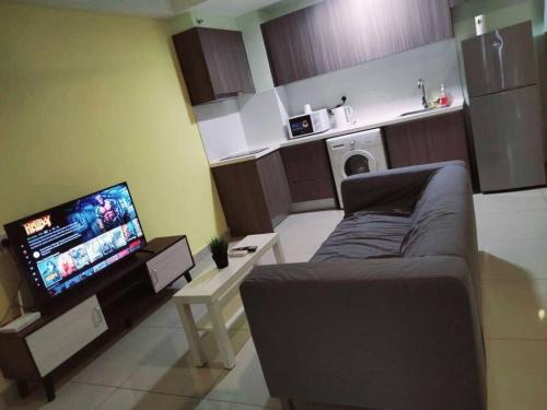 Il comprend un salon doté d'un canapé et d'une télévision à écran plat. dans l'établissement HB2103- Cyberjaya- WiFi- Netflix-Parking, 3046, à Cyberjaya