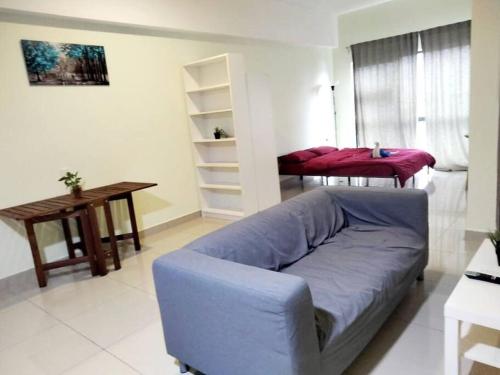 een woonkamer met een blauwe bank en een tafel bij HB2103- Cyberjaya- WiFi- Netflix-Parking, 3046 in Cyberjaya