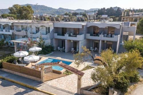 un gran edificio blanco con piscina en Yianna Apartments en Faliraki