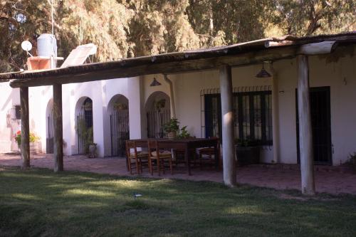 eine Veranda eines Hauses mit einem Tisch und Stühlen in der Unterkunft La Finca de Buen Orden in San Martín