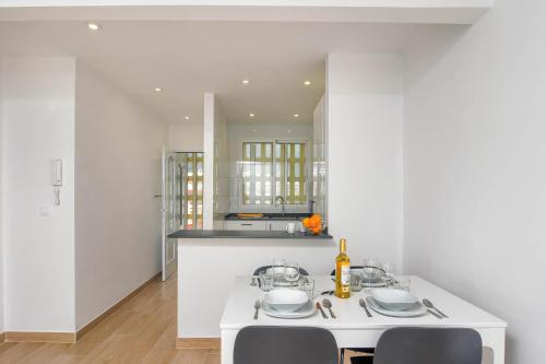 - une cuisine blanche avec une table et des chaises blanches dans l'établissement Appartement La Perla Seaview Calpe, à Calp