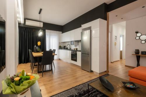 a kitchen and living room with a table and a dining room at Acropolis Exclusive Apartment in Athens