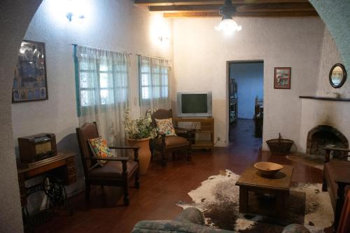 a living room with a fireplace and a tv at La Finca de Buen Orden in San Martín