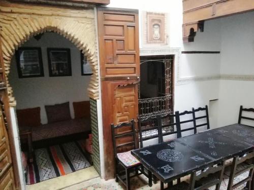 Cette chambre comprend une table, une porte, une table et des chaises. dans l'établissement Dar Ines, à Moulay Idriss Zerhoun