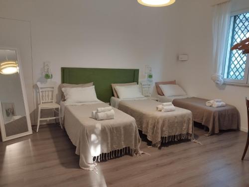 a room with two beds and two tables in it at Saja Country House in Acireale