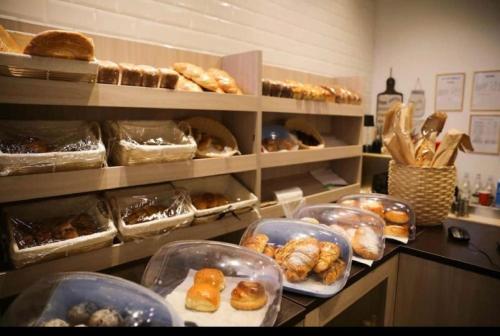 une boulangerie avec de nombreux types de pâtisseries différents sur un comptoir dans l'établissement Студия ТЕРРАКОТА в центре с шикарным видом на горы, à Almaty