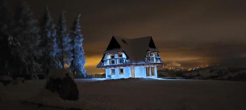 a house with a x on it at night at NOWA CHATA in Bustryk