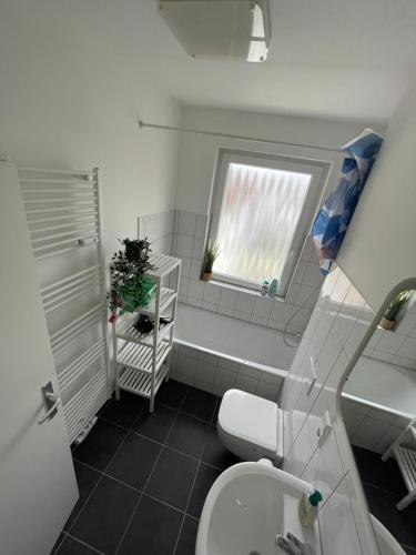 ein Bad mit einem WC, einem Waschbecken und einem Fenster in der Unterkunft City-Apartments Hannover in Hannover