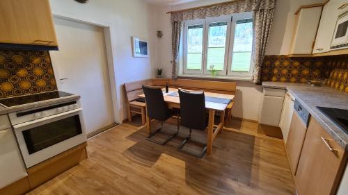 a kitchen with a table and chairs in a room at HH-Apartments in Scheifling