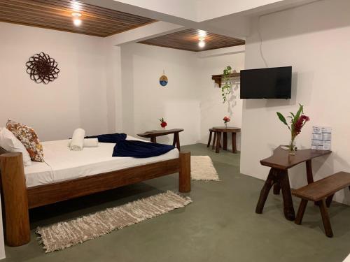 a bedroom with a bed and a flat screen tv at NuMar Tubarão Pousada - Barra Grande in Barra Grande