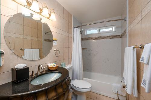a bathroom with a sink and a toilet and a mirror at Casa Mariquita Hotel by Omeo in Avalon