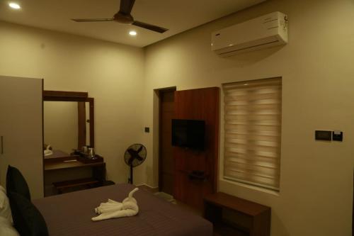 - une chambre avec un lit avec un animal blanc dans l'établissement Casa Orchid, à Alappuzha
