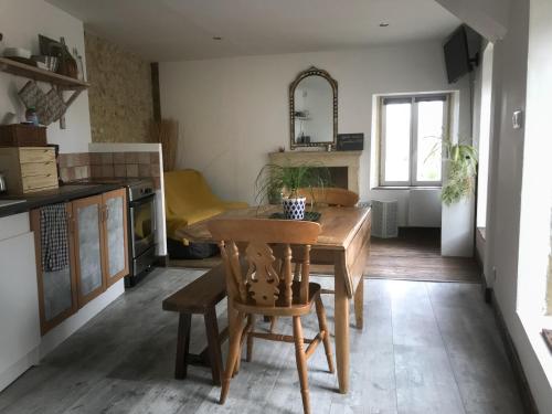 une cuisine avec une table en bois et une salle à manger dans l'établissement Idha à proximité de Bayeux, à Vaucelles