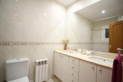 a bathroom with a sink and a toilet and a mirror at Nice new apartment only 30min to Barcelona center. in Granollers