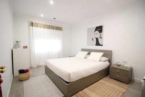 una camera bianca con un letto e una finestra di Nice new apartment only 30min to Barcelona center. a Granollers