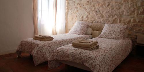 Dos camas en un dormitorio con dos toallas. en La Planque des Frères, en Rivières