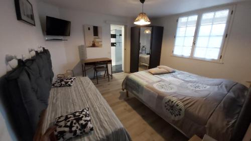1 dormitorio con 2 camas y mesa. en Le Mas d'Evlie, en Aubin