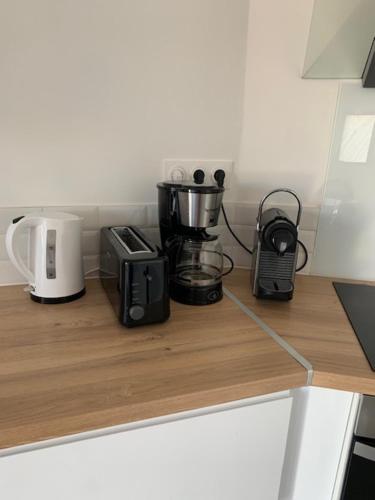 a kitchen counter with appliances on a wooden counter top at La Parenthèse maison T3 au calme avec parking gratuit in Les-Pennes-Mirabeau
