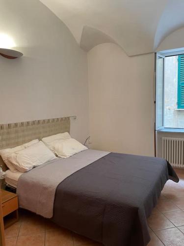 a bedroom with a bed in a room with a window at Appartamento a due passi dal mare in Finale Ligure
