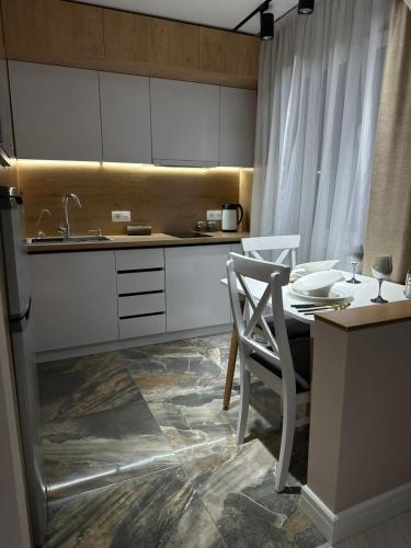 eine Küche mit einem Tisch, einem Stuhl und einem Waschbecken in der Unterkunft Nursultana Nazarbaeva 20 Str by Slissenko Inn in Pawlodar
