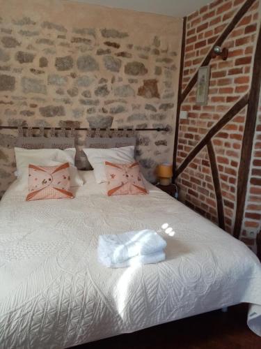um quarto com uma cama branca e almofadas cor-de-rosa em Chambre Rdc em Saint-Aubin-le-Monial