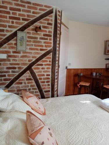 um quarto com uma parede de tijolos e uma cama em Chambre Rdc em Saint-Aubin-le-Monial