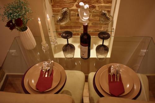 Harmony 2 in Gold في لافريو: طاولة مع طبقين وزجاجة من النبيذ
