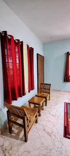 a room with benches and red curtains on a wall at Forest Cabin Bugyal Stays in Pauri
