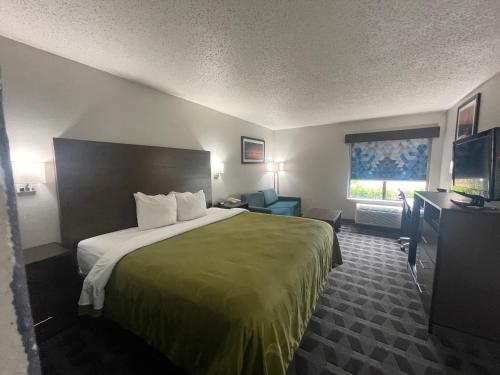ein Hotelzimmer mit einem Bett und einem TV in der Unterkunft Quality Inn in Hillsboro