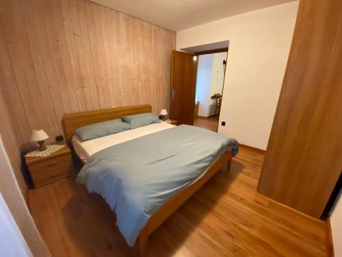 a bedroom with a bed and a wooden floor at Appartamento Alessio in Ledro