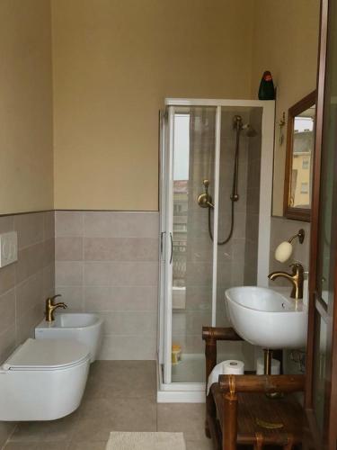 uma casa de banho com 2 lavatórios, uma banheira e um chuveiro em casa silvio pellico em Cuneo