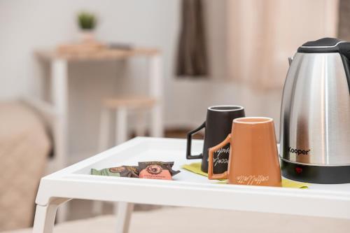 eine Kaffeekanne und zwei Tassen auf dem Tisch in der Unterkunft Emperooms Guest House in Rom