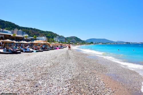 a beach with a crowd of people and the ocean at Sunwaves Beach studio I in Ialyssos