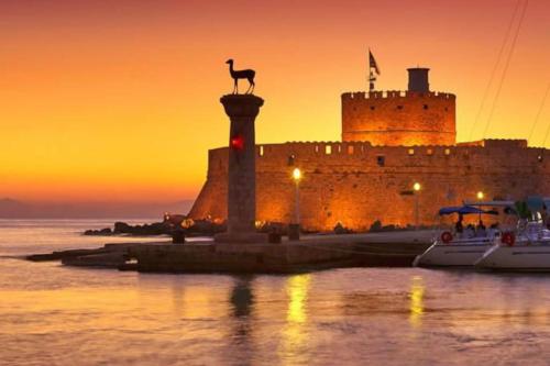 a castle with a statue of a giraffe on a pole in front at Sunwaves Beach studio I in Ialyssos