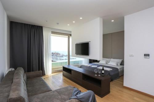 1 dormitorio con cama, sofá y TV en Apartments Lux sea view, en Budva