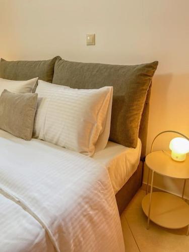 a bedroom with a bed with pillows and a table at Afroditi's Apartment Superb View in Gythio