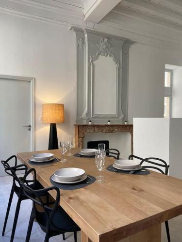 une table à manger avec des chaises et une cheminée dans l'établissement Appartement avec ventilateurs proche du Palais des Papes, à Avignon