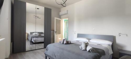 - une chambre avec un grand lit et un miroir dans l'établissement Welcome Migliarina 2, à La Spezia
