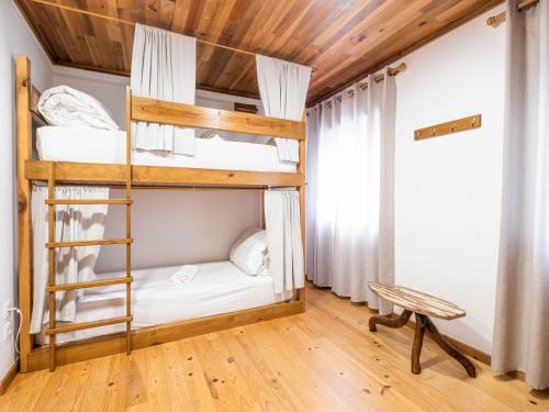 a bedroom with bunk beds in a room with wooden ceilings at Castaway in Baleal
