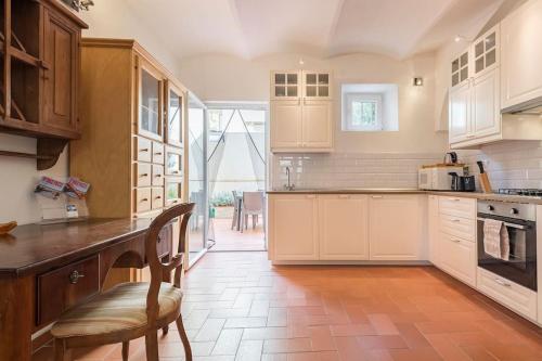 a kitchen with white cabinets and a table and chairs at DaLu Florence apartment Davide - private car park 15 minutes to the city center in Florence