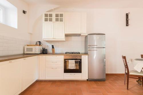 a kitchen with white cabinets and a stainless steel refrigerator at DaLu Florence apartment Davide - private car park 15 minutes to the city center in Florence