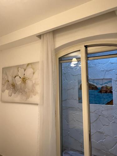 a sliding glass door with a window and a painting at Maison Mele Ischia in Ischia