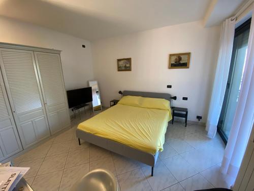a bedroom with a yellow bed and a desk at Central loft Des Etrangers in Sanremo