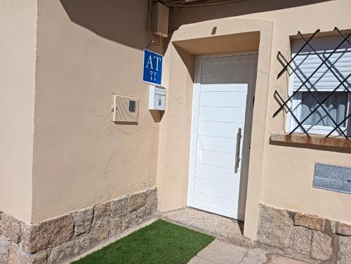 a building with a white door and a sign at Conde de la Encina in Trujillo