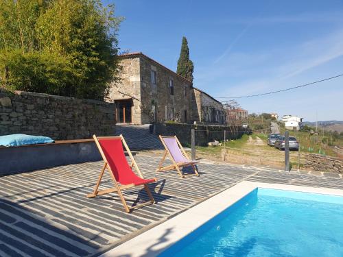 2 sedie sedute su una terrazza accanto alla piscina di Quinta de Sobre a Fonte Charming Apartments a Fontelas