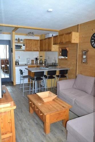 un salon avec un canapé et une table et une cuisine dans l'établissement Appartement Valfréjus Thabor A pieds de pistes, à Modane