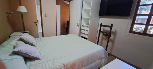 Dormitorio pequeño con cama y TV en La Marta en Luján de Cuyo